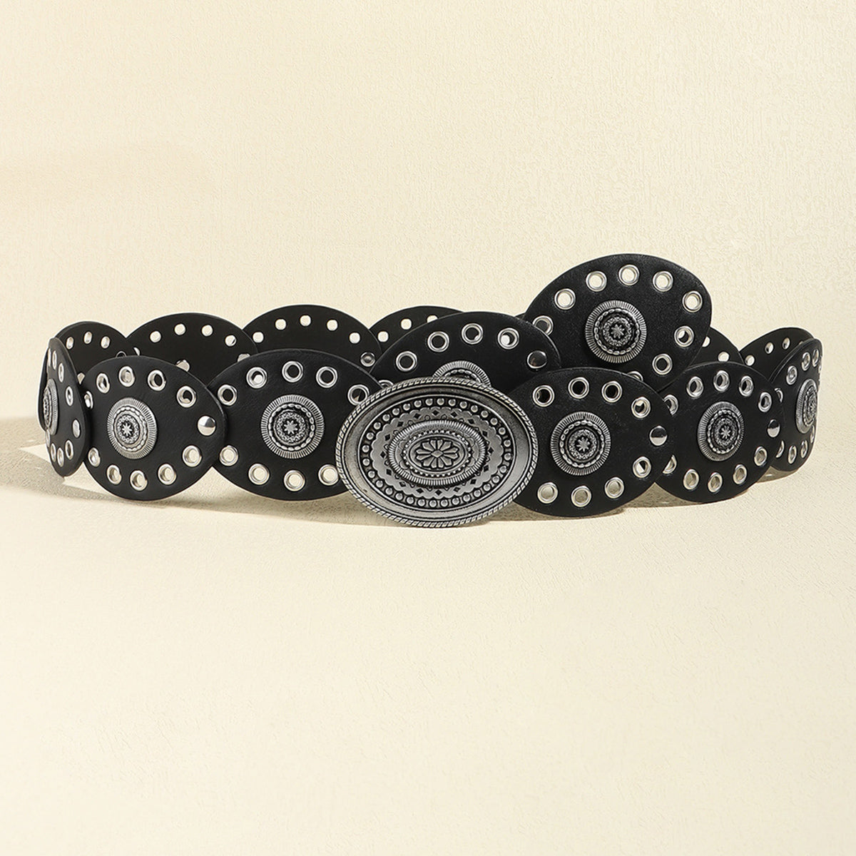 Black belt with silver circular patterns on a beige background
