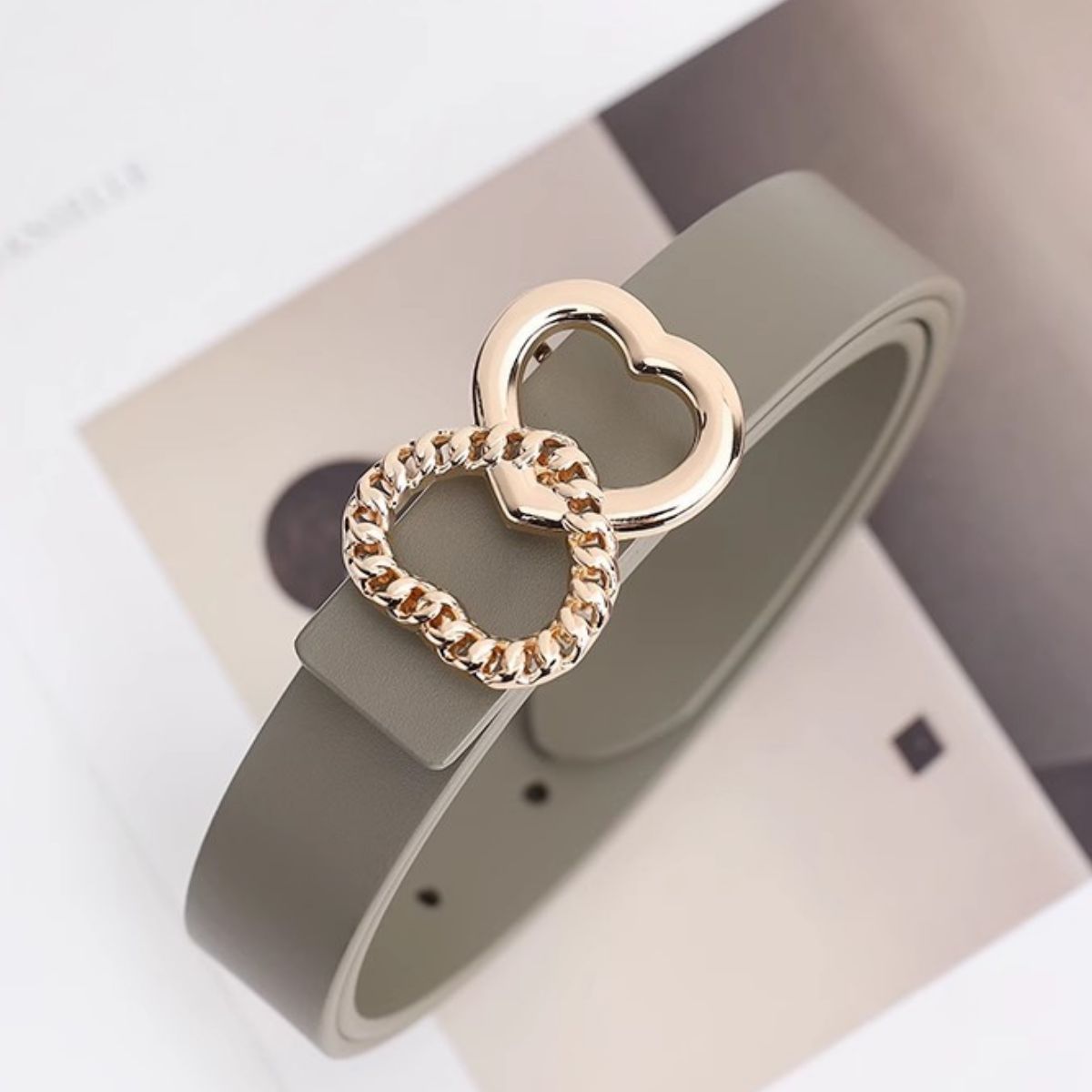 Gray belt with a gold heart-shaped buckle on a white background