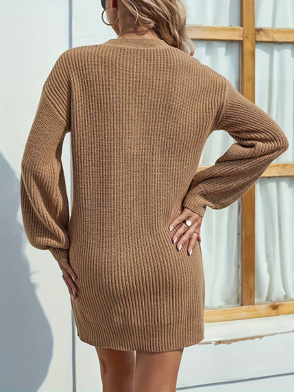 Brown knit dress worn by a person standing against a light-colored wall.