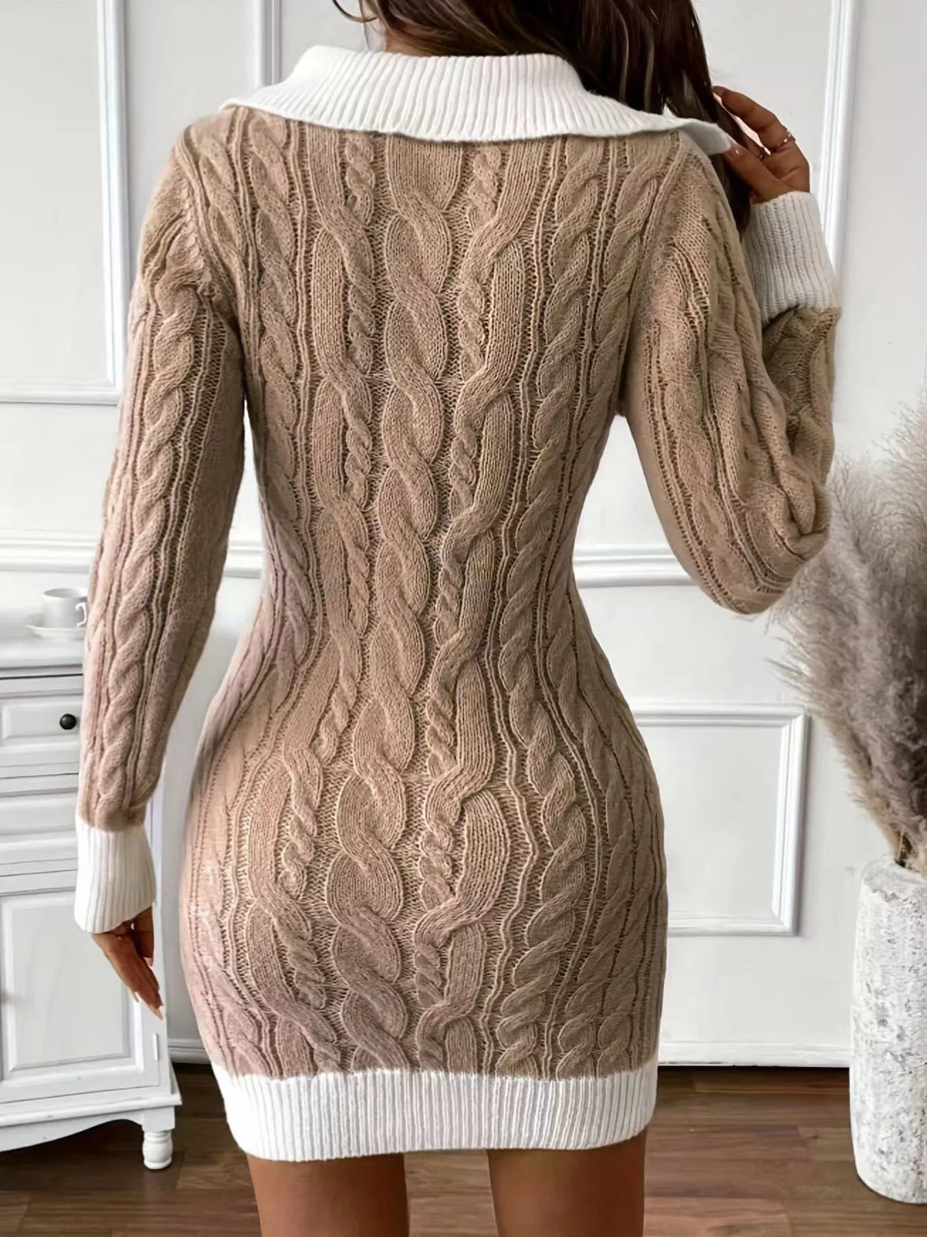 Beige cable knit sweater dress with white collar and cuffs worn by a person.