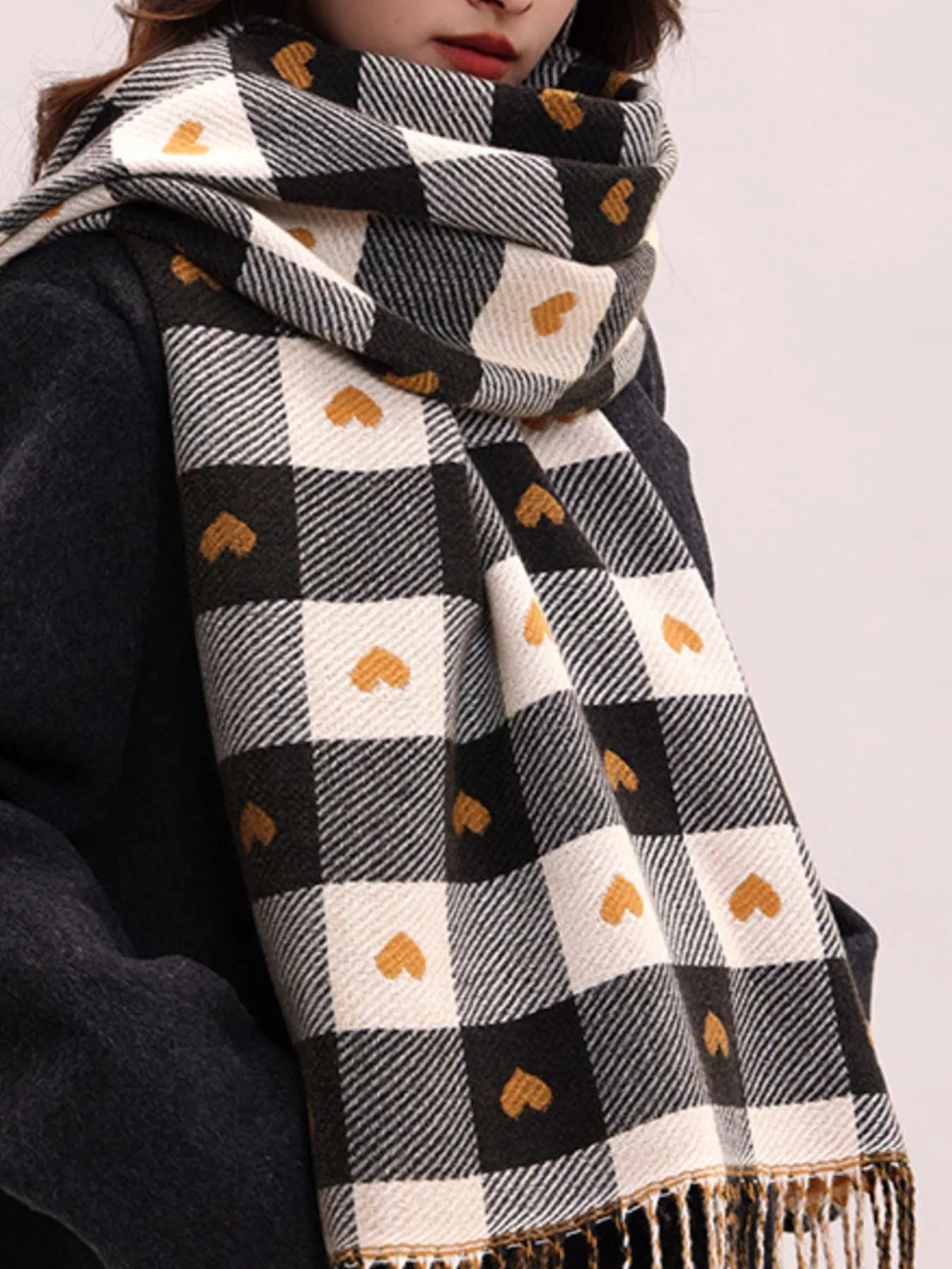 Plaid scarf with heart patterns worn by a model on a white background